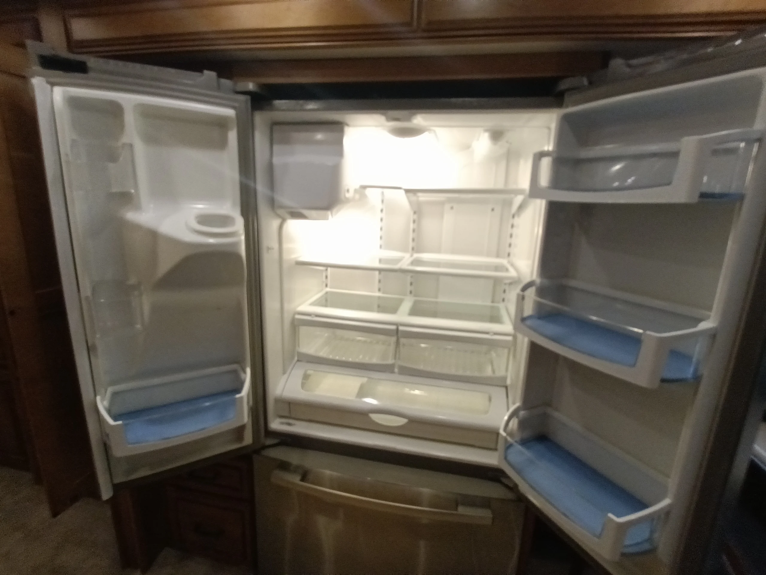 IMG_20260710_172412_891 Open, spacious refrigerator inside a motorcoach or RV, showcasing multiple shelves and door compartments.