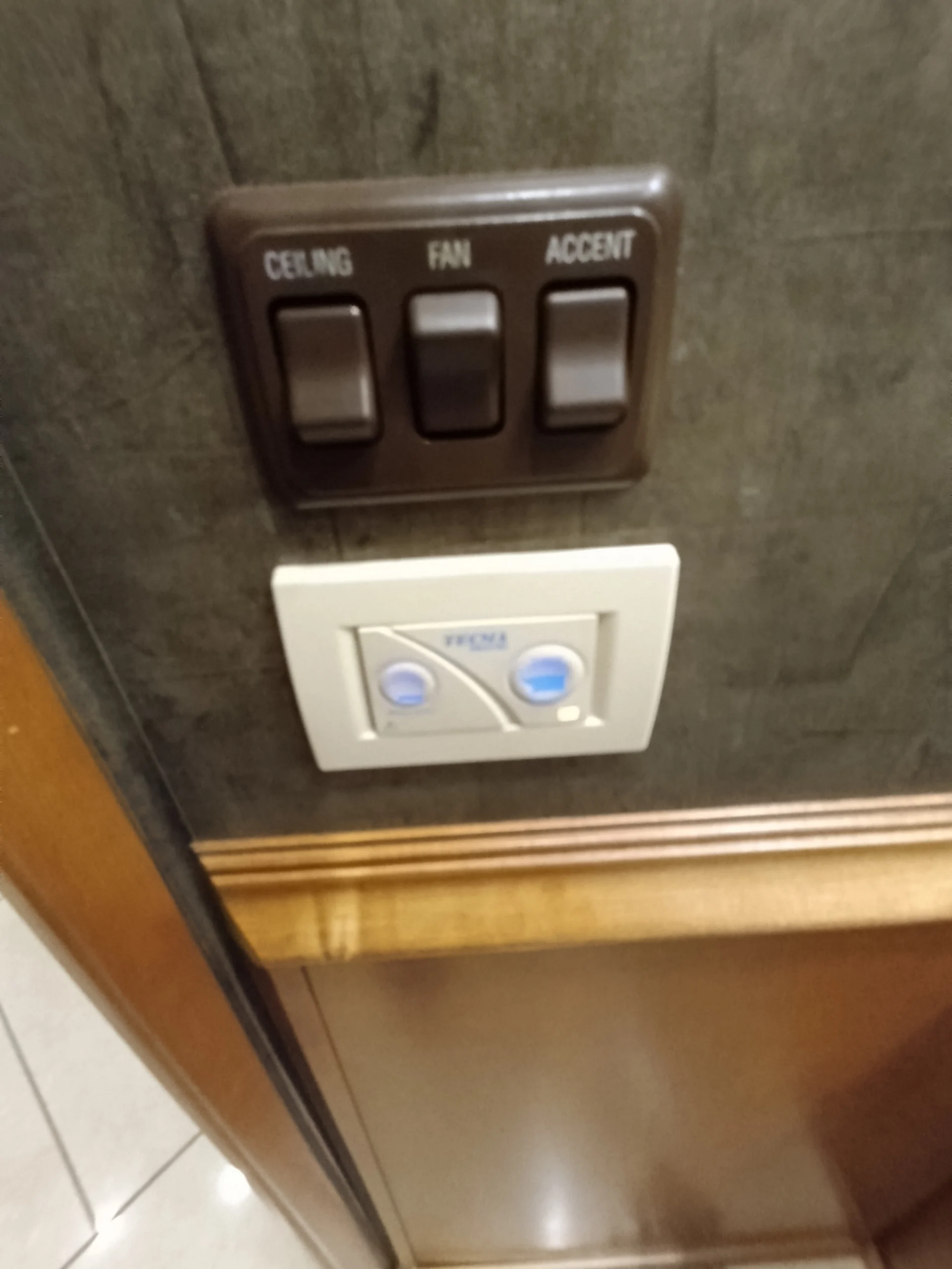 IMG_20260710_172739_859 Wall switches for ceiling, fan, and accent in a Motorcoach and RVs interior, brown and white panels.