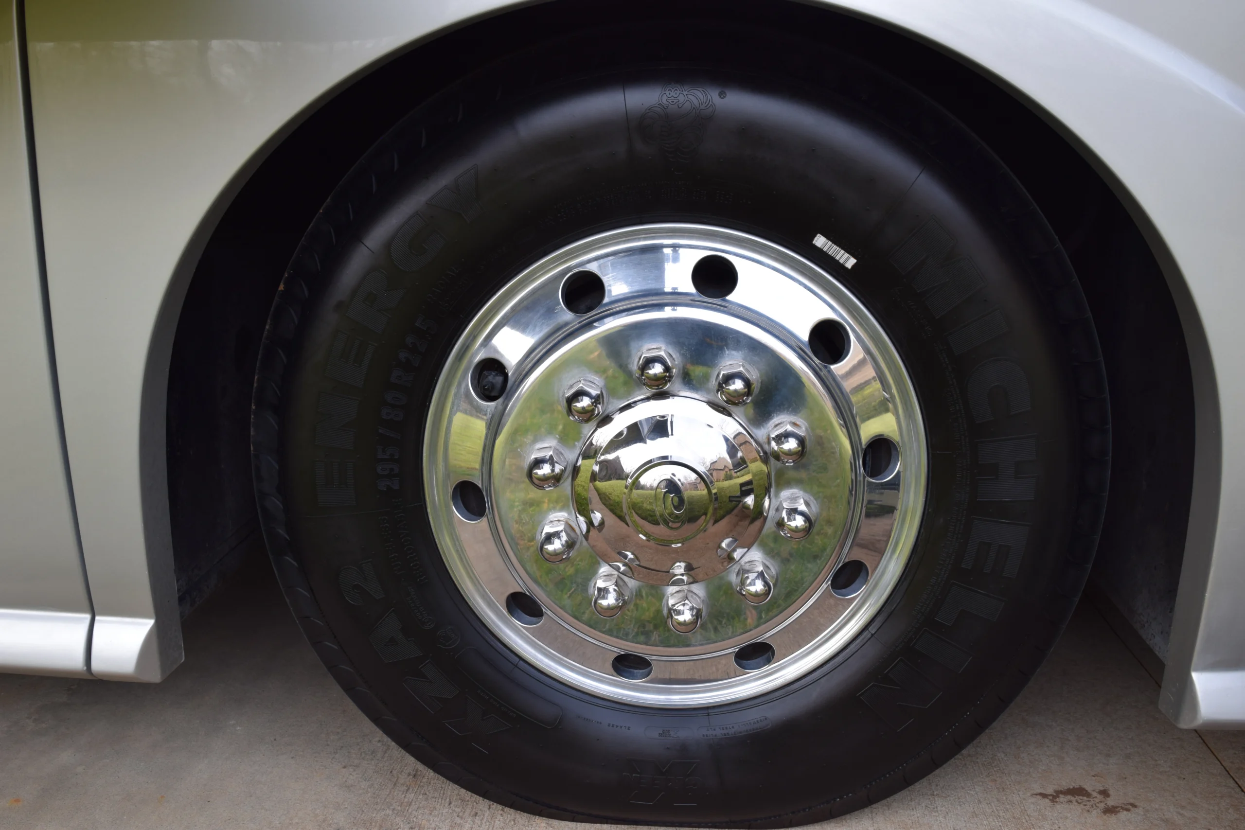DSC_0157 Shiny silver motorcoach and RVs wheel with a reflective hubcap and visible tire branding.