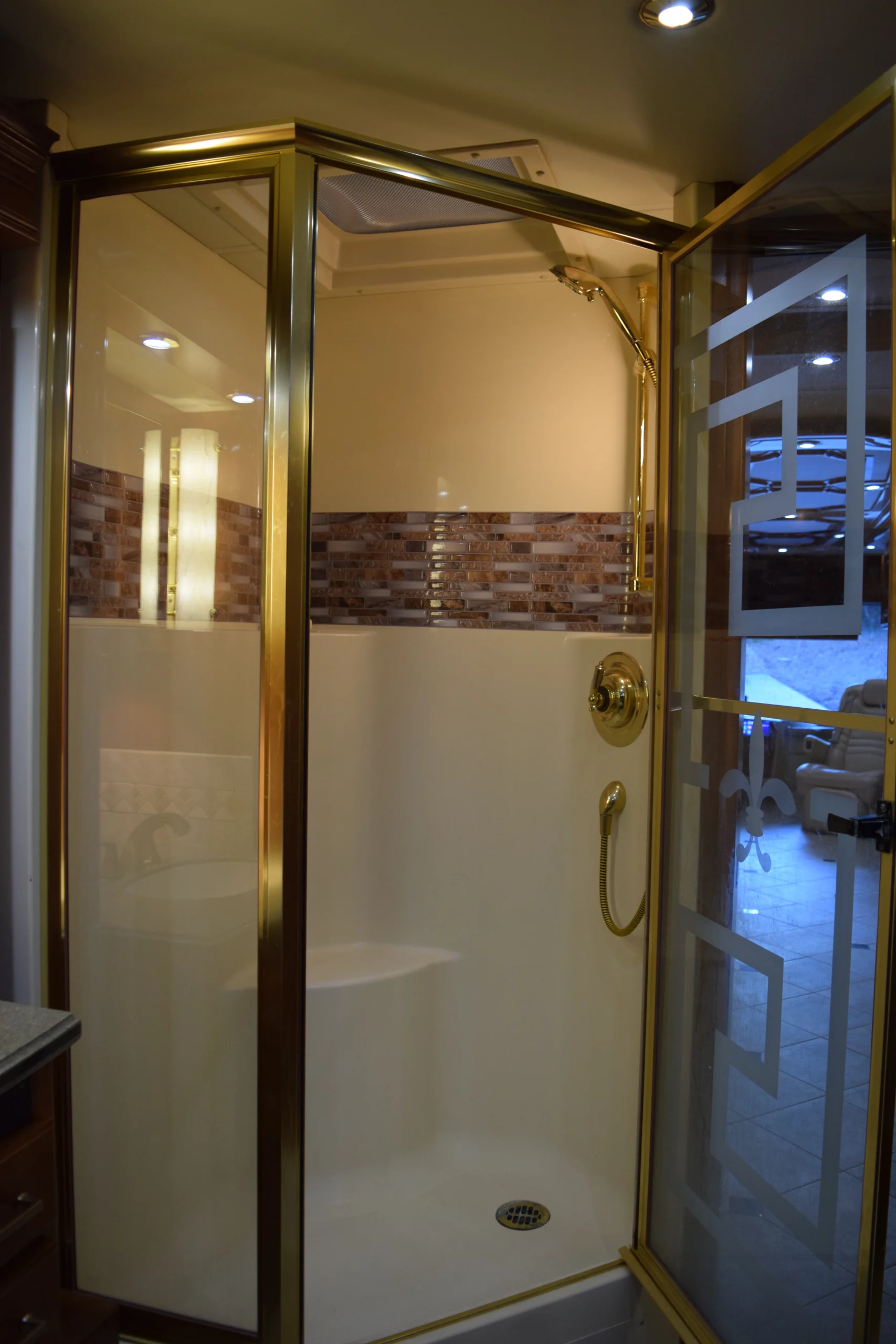 DSC_0189 Luxurious shower with gold trim and mosaic tiles in a Motorcoach and RVs bathroom.