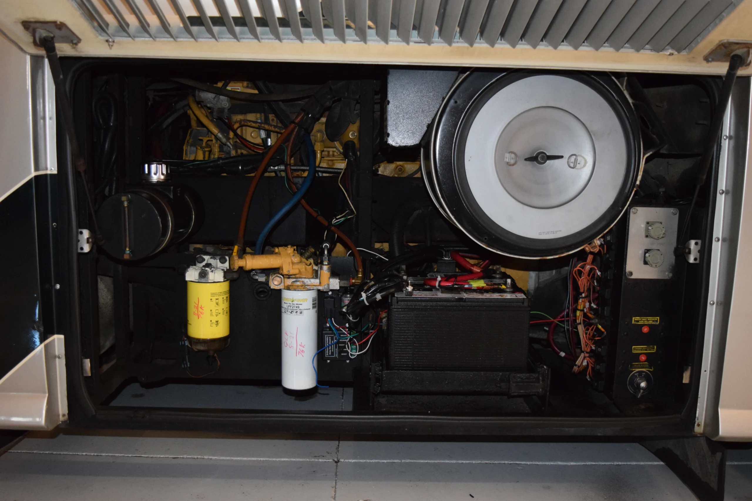 DSC_0215 Engine compartment showcasing intricate wiring, filters, and battery of a Motorcoach and RVs vehicle.