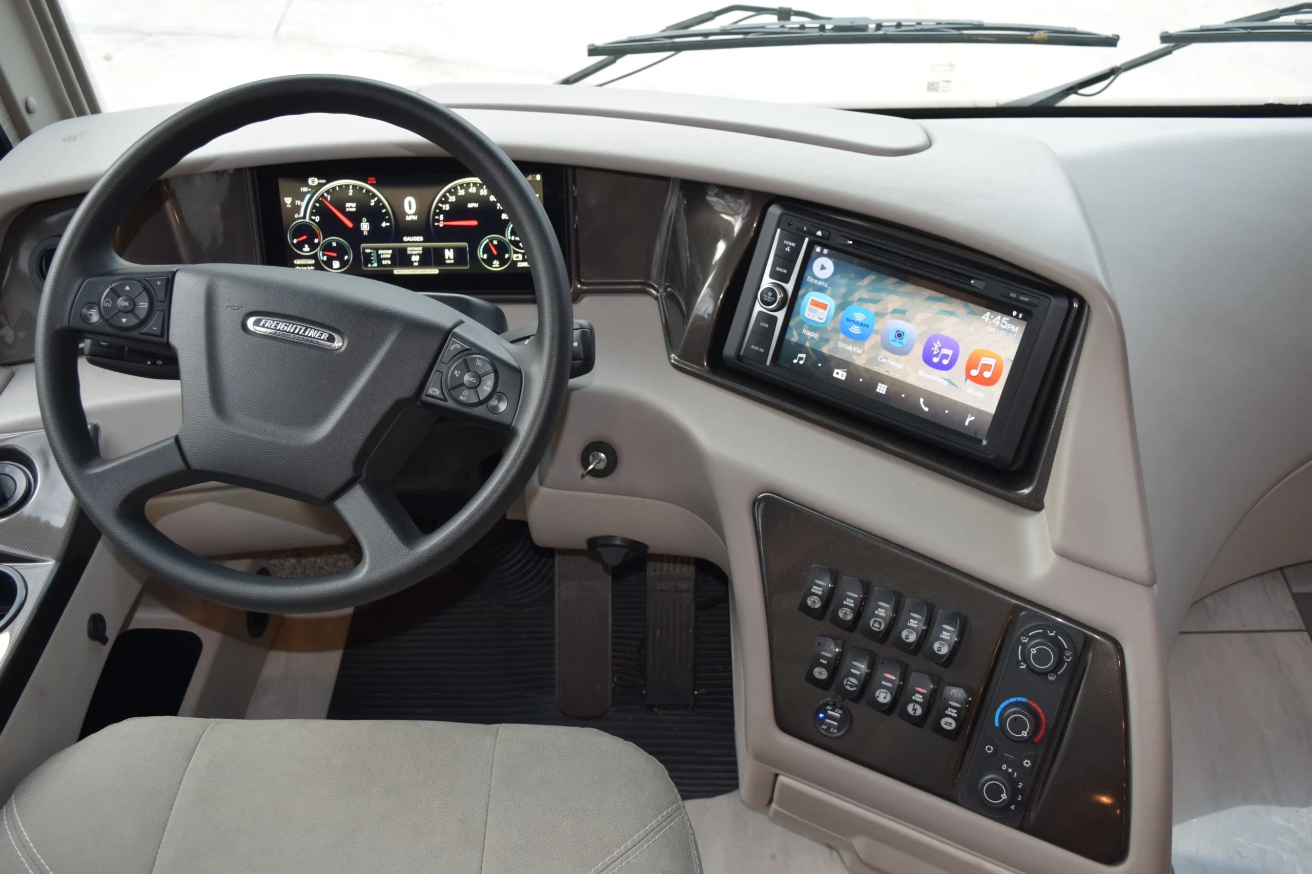 DSC_0288 Motorcoach and RVs dashboard with a steering wheel, digital speedometer, touchscreen display, and control switches for easy navigation.
