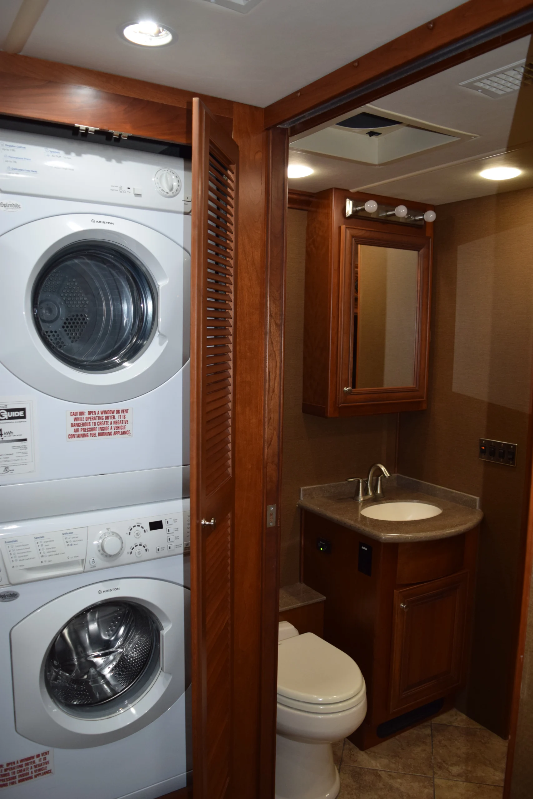 DSC_0343 Motorcoach and RVs bathroom with stacked washer and dryer beside a compact sink and toilet.