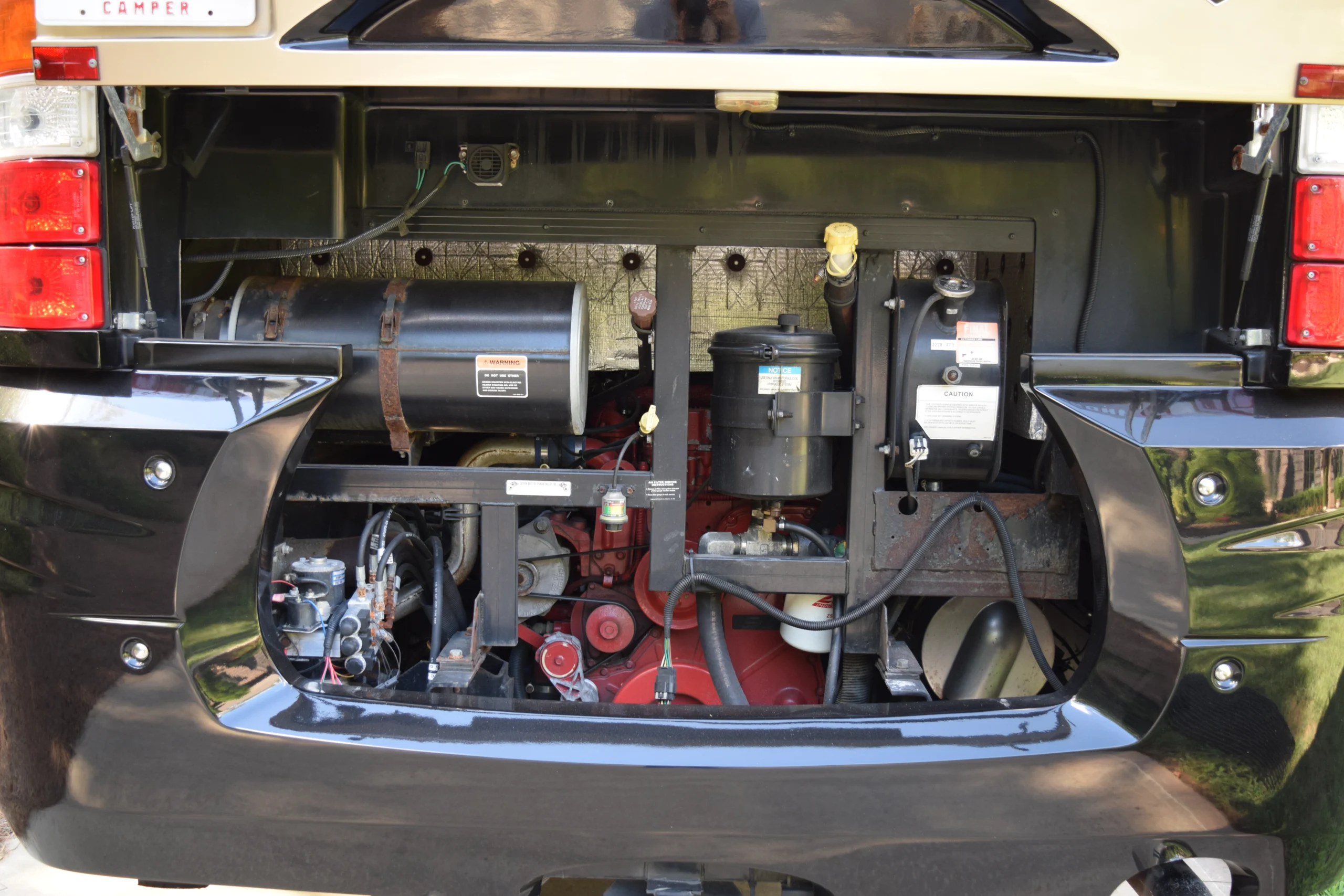 DSC_0354 Open engine compartment of a motorcoach featuring various mechanical components and wiring.