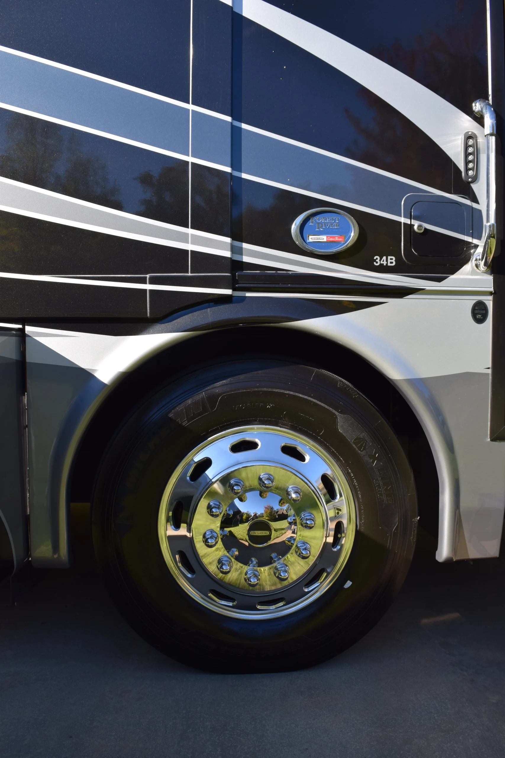 DSC_0698 Motorcoach rear wheel with shiny chrome hubcap and sleek black and silver stripes, showcasing the model 34B detail.