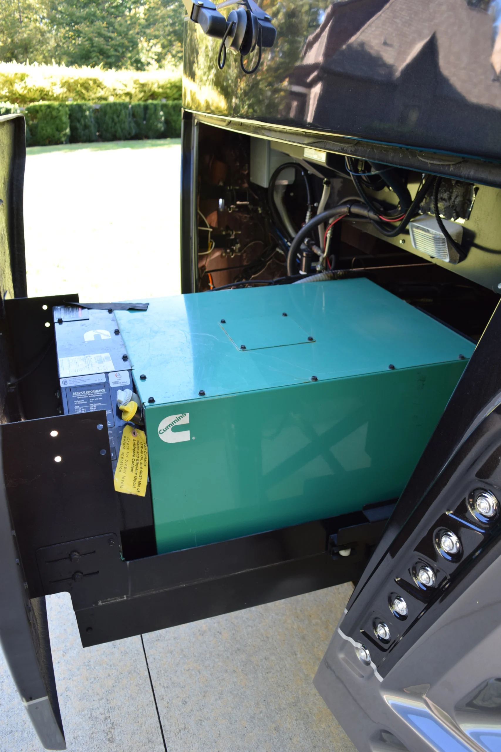 DSC_0705 Green generator mounted in an RV compartment, partially extended, showcasing cables and connectors. Motorcoach and RVs maintenance setup.