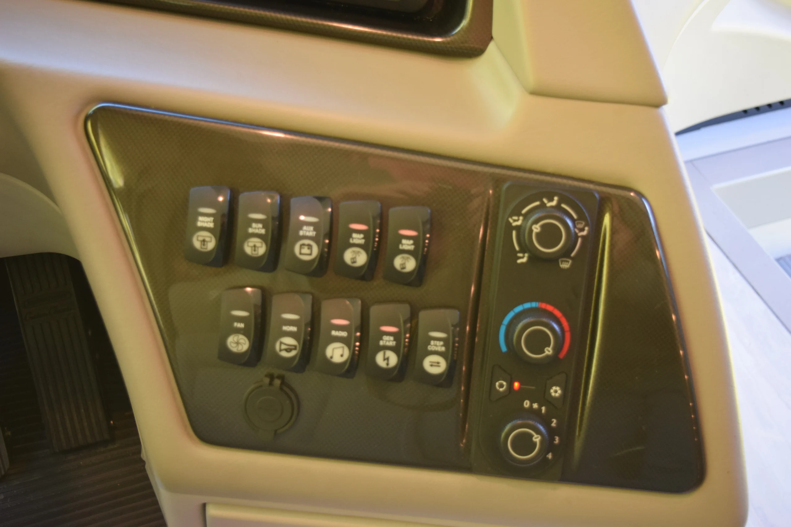 DSC_0715 Dashboard control panel in a Motorcoach and RVs, featuring switches and knobs for climate, shades, and other functions.