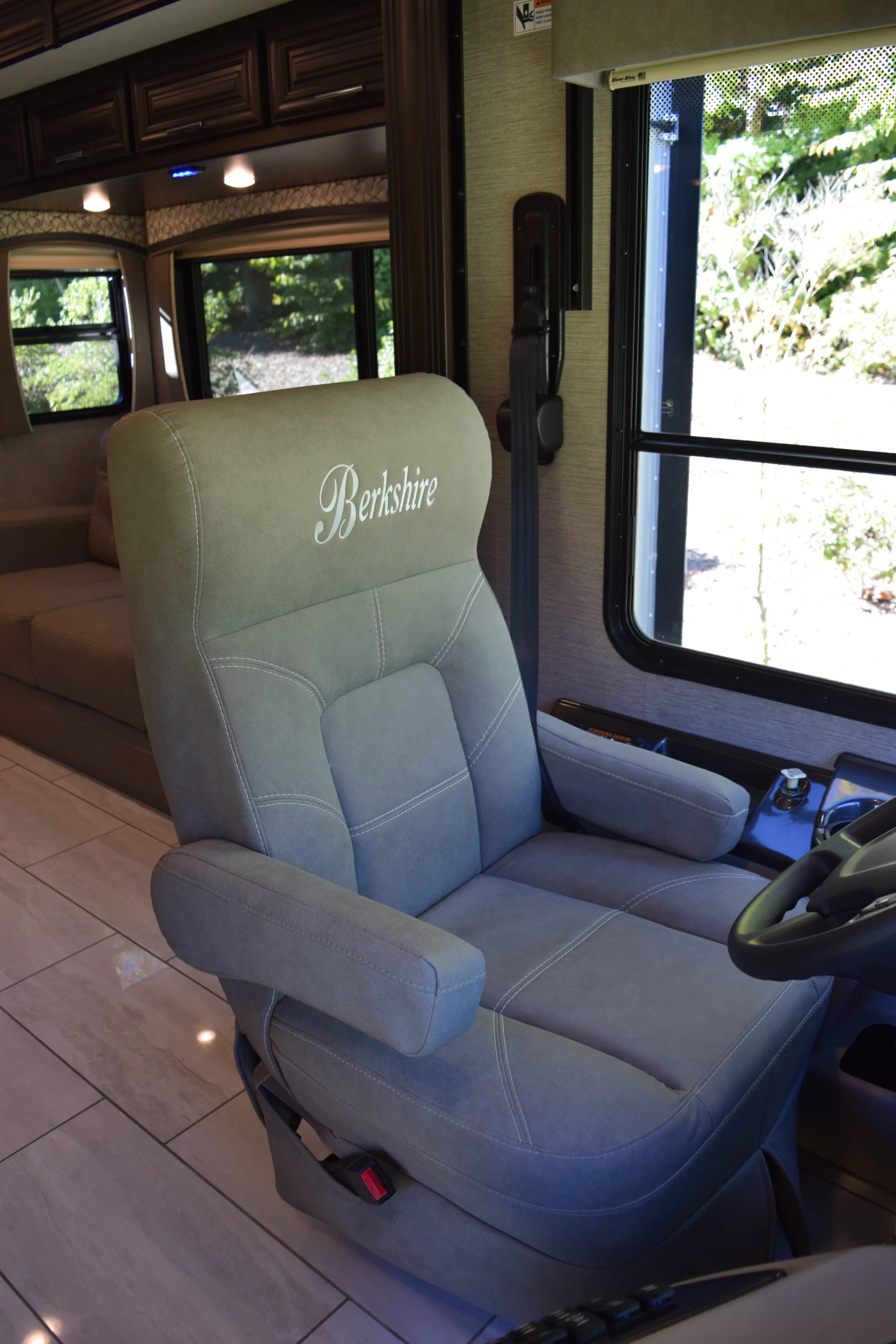 DSC_0722 Plush Berkshire driver's seat in Motorcoach, near large window, soft lighting enhancing interior comfort.