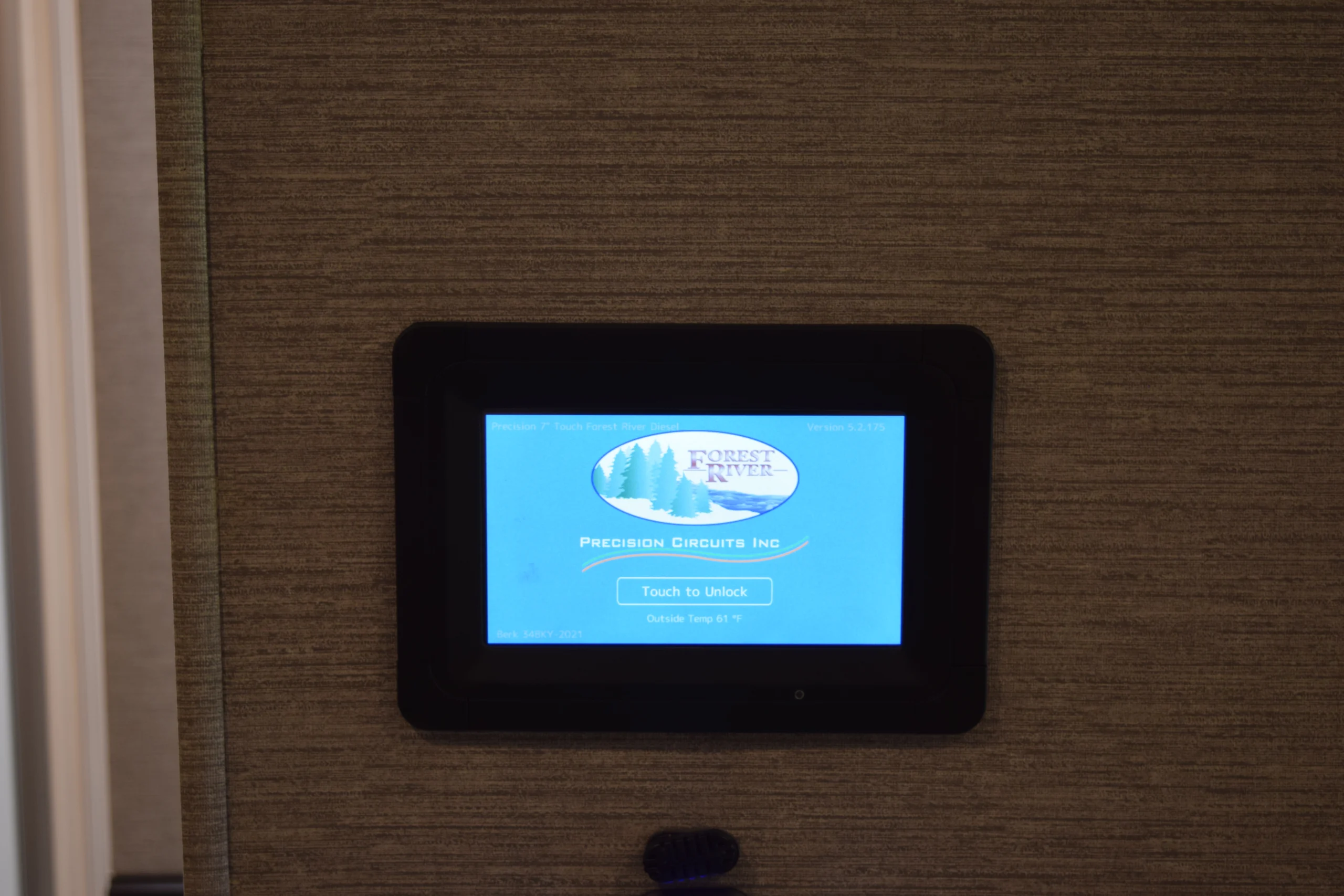 DSC_0758 Touchscreen panel in a Motorcoach showing Precision Circuits Inc interface with "Touch to Unlock" on blue screen, temperature displayed.